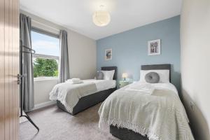 a bedroom with two beds and a window at 3BR Warwick Uni-Free Parking, Fast WiFi in Canley