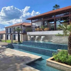 a house with a swimming pool in front of a building at Quinta Santa Bárbara Eco Resort in Pirenópolis +14 photos