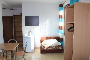 a small room with a table and a chair and a kitchen at Albatros in Gąski
