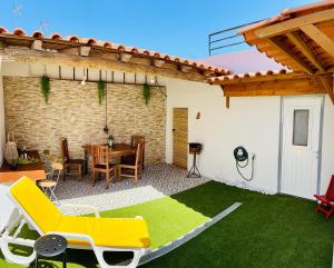 a patio with a table and a yellow chair at Sado Guest House in Alcácer do Sal