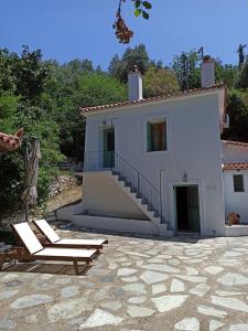 een huis met een trap en 2 ligstoelen bij Casa de la Fuente in Ditropo