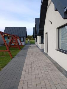 a brick walkway next to a building at Domki Anusia Niechorze in Niechorze