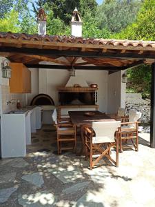 een patio met een tafel en stoelen en een keuken bij Casa de la Fuente in Ditropo