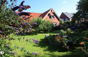 uma casa com um quintal com flores e plantas em Ferienhaus Berghaus em Norderney