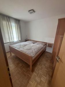 a bedroom with a bed and a wooden floor at Romy in Deutschlandsberg