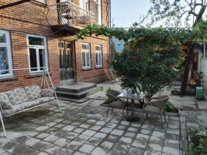 a patio with a table and chairs in front of a building at AMBROssador Yanko in Ambrolauri