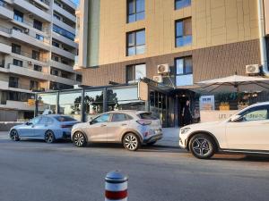 three cars parked on a street in front of a building at Jeni's studio in Constanţa
