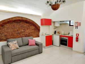 a living room with a couch and a brick wall at Estúdio no centro histórico de Évora em Portugal in Évora