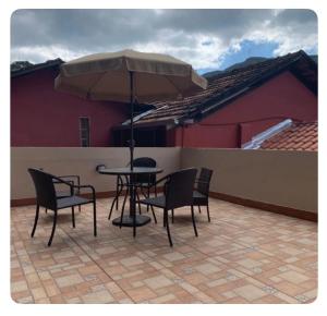 a table and chairs with an umbrella on a patio at Arandela OuroPreto in Ouro Preto