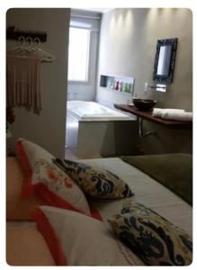 a bathroom with a tub and pillows in a room at Arandela OuroPreto in Ouro Preto