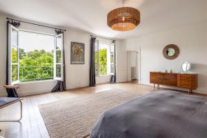 a bedroom with a bed and a dresser and windows at Domaine la Boissière in Grand Brassac +23 photos