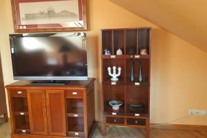 a entertainment center with a flat screen tv on a wooden stand at La Tebaida in Ponferrada