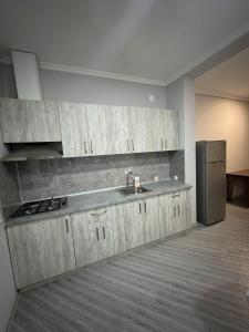 een keuken met een spoelbak en een koelkast bij Rooms on Europe Square in Batoemi