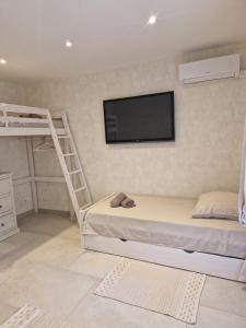 a bedroom with a bunk bed and a flat screen tv at VILLA Soleil et Douceur in La Seyne-sur-Mer