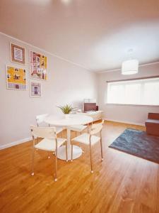 a dining room with a white table and chairs at Alameda Apartments - Apartamento Moderno a 20 min do Porto in Trofa +21 photos