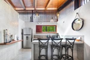 a kitchen with a counter with four stools at Welcome to Paradise - Luxurious 2 Bedroom Oasis with Pool and Lush Tropical Garden in Sayulita