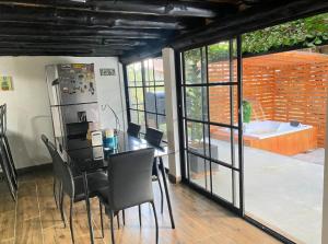 a dining room with a table and chairs and sliding glass doors at Cabaña LA MORADA in Medellín
