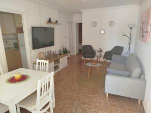 een woonkamer met een tv, een bank en een tafel bij Dreams Holidays in Gran Alacant