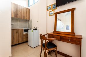a kitchen with a desk and a white refrigerator at Στούντιο Στη Στοά Βαρβουτσή #3 in Kalamata
