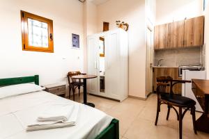 a bedroom with a bed and a table and chairs at Στούντιο Στη Στοά Βαρβουτσή #3 in Kalamata
