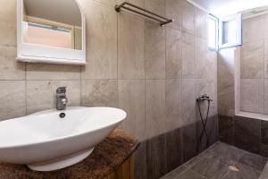 a bathroom with a white sink and a mirror at Στούντιο Στη Στοά Βαρβουτσή #3 in Kalamata