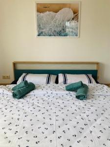 a bed with two green pillows on top of it at Holiday Apartment Calipso in Sozopol