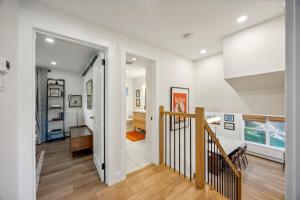 a hallway of a home with white walls and wooden floors at Modern Mid-Century Retreat in West Chester