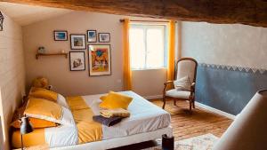 a bedroom with a bed and a chair and a window at Au bon endroit in Sevremont +22 photos