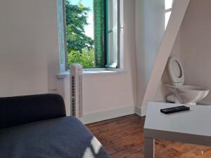a living room with a toilet and a window at chambre prive standard in Châteauroux