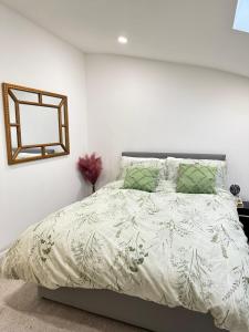 a bedroom with a bed and a mirror on the wall at JayGees luxury homes in Lower Gornal