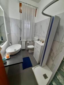 a white bathroom with a toilet and a sink at LAPILLI Holidays in San Giovanni la Punta +76 photos