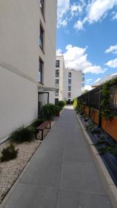 a sidewalk in front of a building with benches at Apartament Stara Elektownia z garażem in Zamość