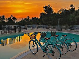 two bikes parked next to a swimming pool at sunset at AGRICAMPEGGIO - SOLO PIAZZOLE VUOTE - Agriturismo Passione Natura in Vieste