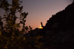 a lighthouse on top of a hill at sunset at Amalfi Luxury House in Amalfi
