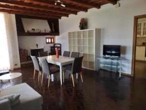 a living room with a table and chairs and a television at Villa Nonna Elisa in Pieve