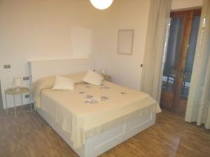 a bedroom with a white bed with blue flowers on it at Villa Nonna Elisa in Pieve