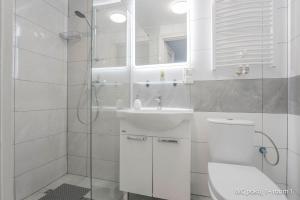 a white bathroom with a toilet and a sink at Remus House Apartments spokojny wypoczynek dla par, tylko pokoje 2-osobowe in Jastrzębia Góra