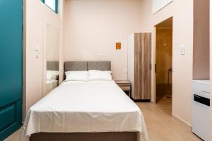 a bedroom with a large white bed in a room at Στούντιο Στη Στοά Βαρβουτσή#9 in Kalamata