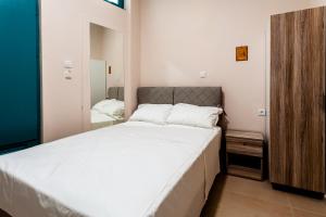 a bedroom with a large white bed and a mirror at Στούντιο Στη Στοά Βαρβουτσή#9 in Kalamata +2 photos