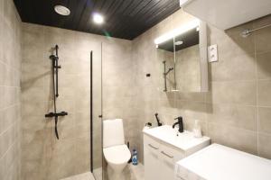 a bathroom with a shower and a toilet and a sink at Forenom Serviced Apartments Tampere Hervanta in Tampere +46 photos