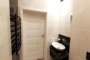a bathroom with a white door and a sink at Luxury Apartment - Rakowicka R15 in Krakow