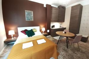a bedroom with a large bed and a small table at Luxury Apartment - Rakowicka R15 in Krakow