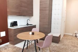 a small kitchen with a wooden table and chairs at Luxury Apartment - Rakowicka R15 in Krakow +17 photos