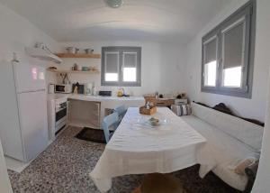 a kitchen with a white table and a white refrigerator at Anastasis Wind Mill in Mármara