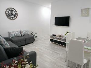 ein Wohnzimmer mit Sofa und Fernseher in der Unterkunft Mare de Deu, vivienda vacacional para familias y mayores de 25 años en el Grao de Gandia-Playa in Puerto de Gandía
