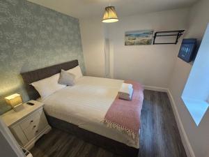 a small bedroom with a bed and a night stand at 3 Eyre Square Lane in Galway