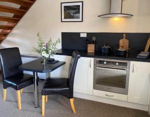a kitchen with a table and a stove at Craven Garth Cottages in Rosedale Abbey +33 photos