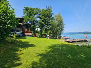a large grassy yard with a house and a lake at "Ellas Home Sekirn" - in 3min am Badestrand in Sekirn