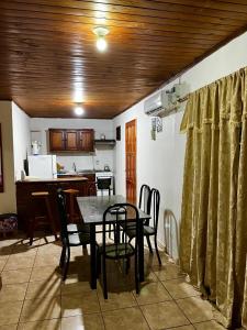 una cucina e una sala da pranzo con tavolo e sedie di DOÑA ROSA a Puerto Iguazú