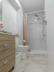 ein weißes Badezimmer mit Dusche und Toilette in der Unterkunft Mare de Deu, vivienda vacacional para familias y mayores de 25 años en el Grao de Gandia-Playa in Puerto de Gandía